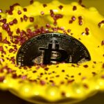 Eine Bitcoin-Münze liegt in einer gelben Schale, umgeben von rosa Zuckerkristallen.