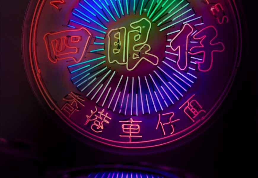 Neon-Schild mit dem Schriftzug 'Nerdy Noodles' in bunten Farben und reflektierender Oberfläche.