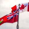 Die kanadische Flagge und die Flagge von Ontario wehen im Wind an einem Flaggenmast.