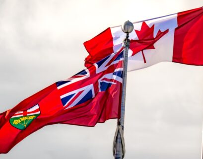 Die kanadische Flagge und die Flagge von Ontario wehen im Wind an einem Flaggenmast.
