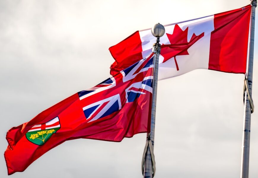 Die kanadische Flagge und die Flagge von Ontario wehen im Wind an einem Flaggenmast.