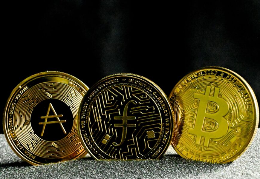 Drei goldene Kryptowährungs-Münzen mit Symbolen für verschiedene digitale Währungen.