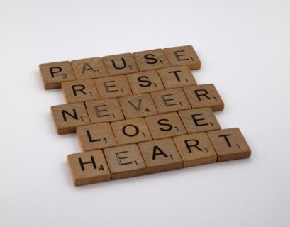 Scrabble-Buchstaben, die die Worte 'Pause', 'Ruhe', 'Niemals', 'Herz' und 'verlieren' bilden.